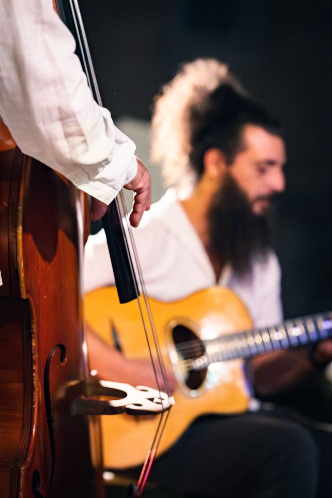 Guitariste en plein jeu sur scène, lumière de scène chaleureuse.