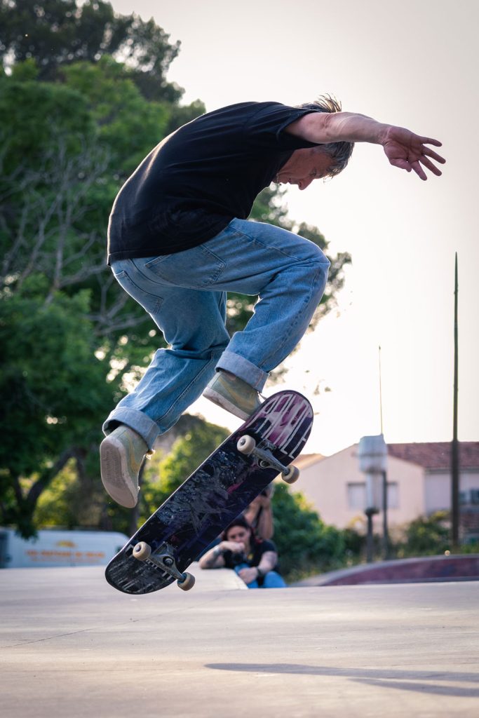Skateur en plein saut en extérieur, figure aérienne.