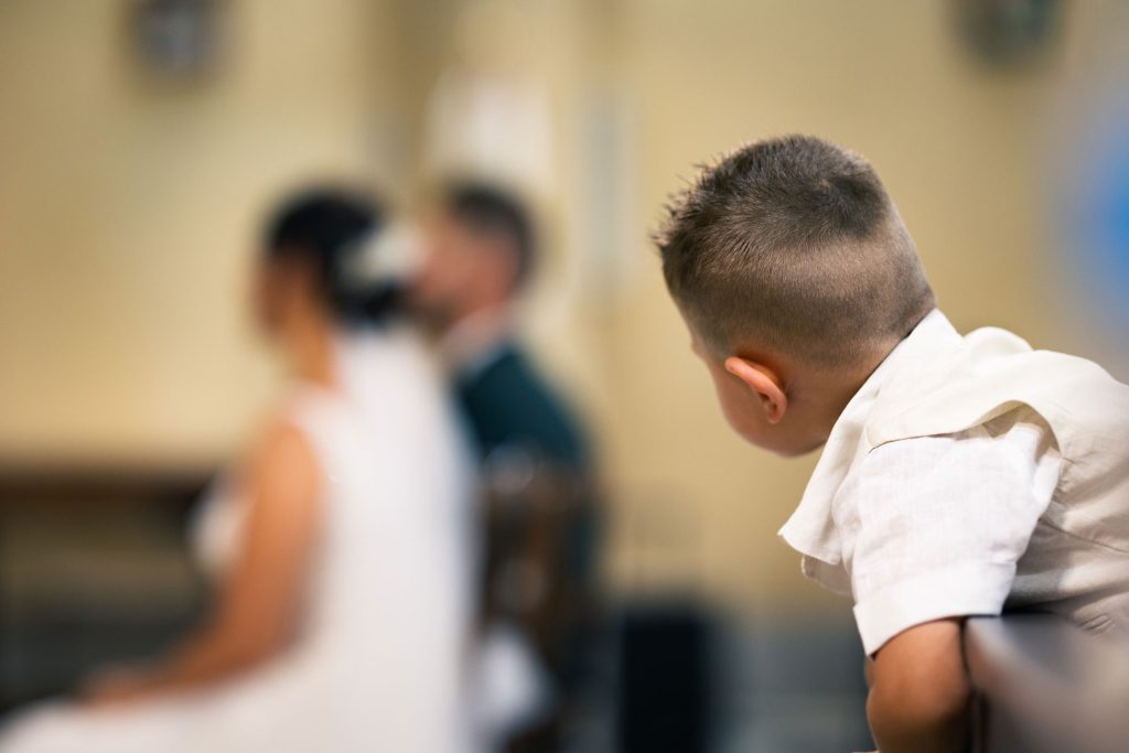 Enfant regardant la cérémonie religieuse, instant naturel et attendrissant.
