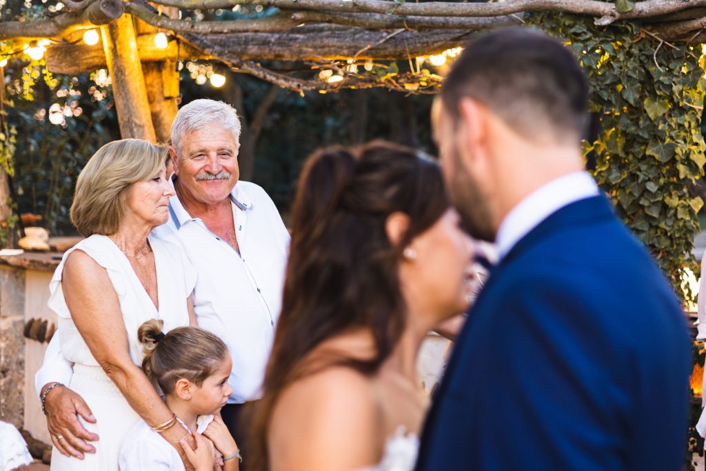 Famille réunie et souriante pendant un mariage en extérieur, ambiance chaleureuse et naturelle.