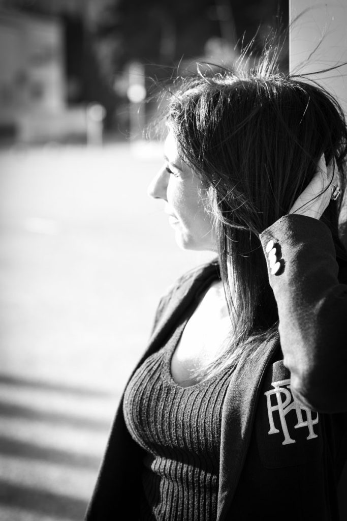 Portrait urbain en noir et blanc, lumière naturelle latérale, expression douce.